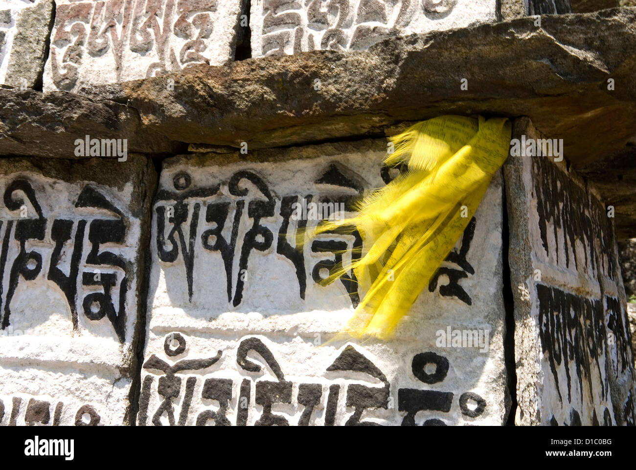 Sagarmatha Nationalpark Region Khumbu, Nepal. Ein Gebetsfahne flattert zwischen Mani-Steinen mit einem buddhistischen Mantra eingeschrieben. Stockfoto