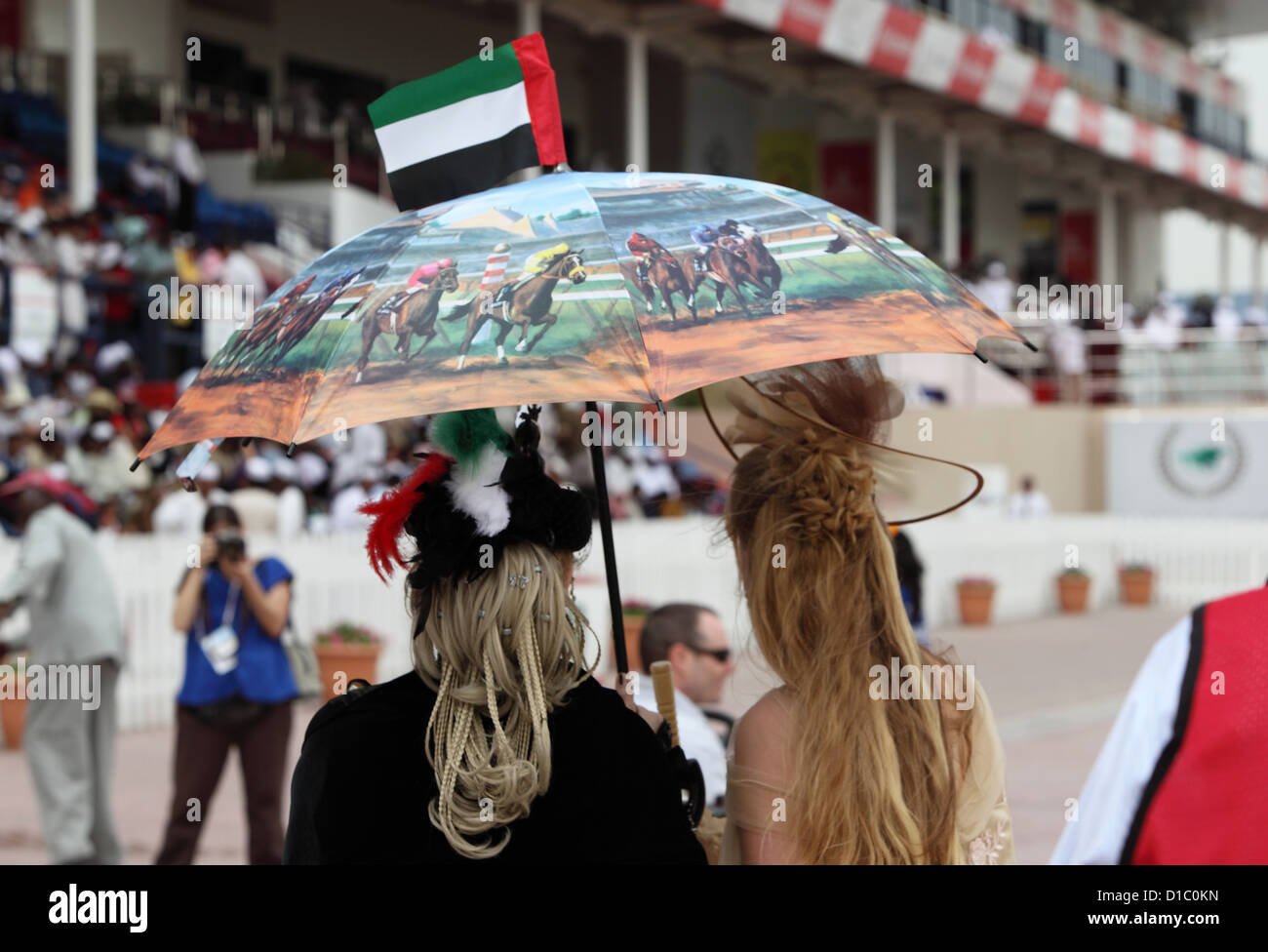 Dubai, Vereinigte Arabische Emirate, Frauen mit Hut und Sonnenschirm auf  der Rennbahn Stockfotografie - Alamy