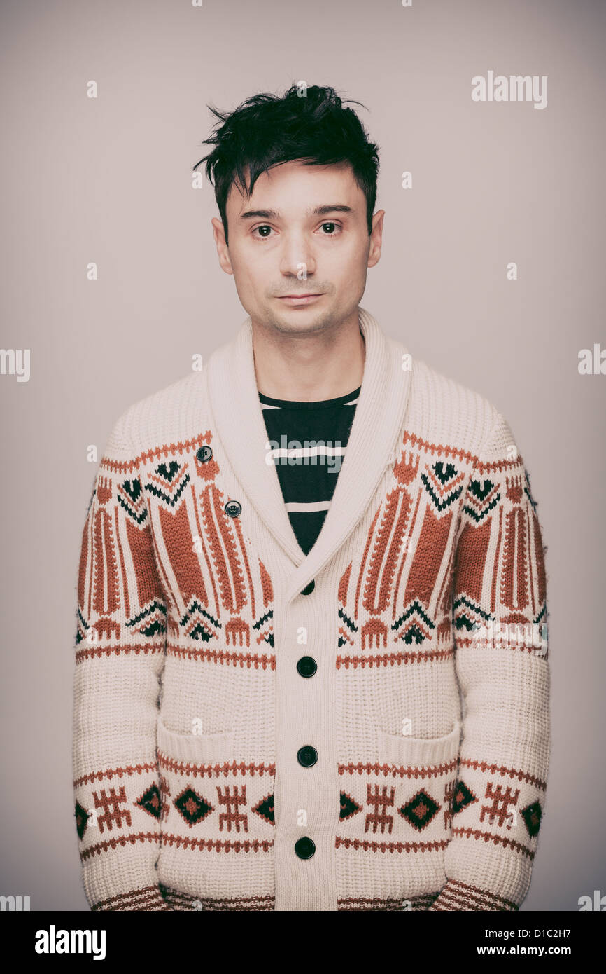 Ernster Mann in weiß, gemusterten wollene Strickjacke und Schwarzes T-shirt aus Baumwolle. Stockfoto