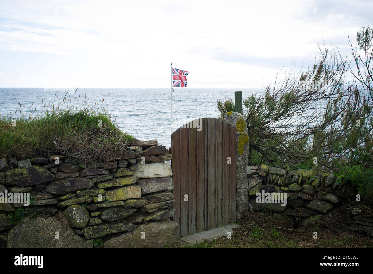 Union Jack-Flagge im Garten am Meer, Gunwalloe, Cornwall. Stockfoto