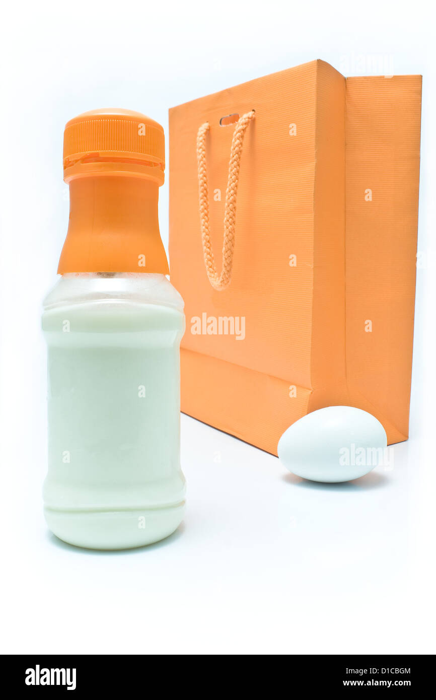 Flasche Milch, Ei und Einkaufstasche auf weißem Hintergrund Stockfoto