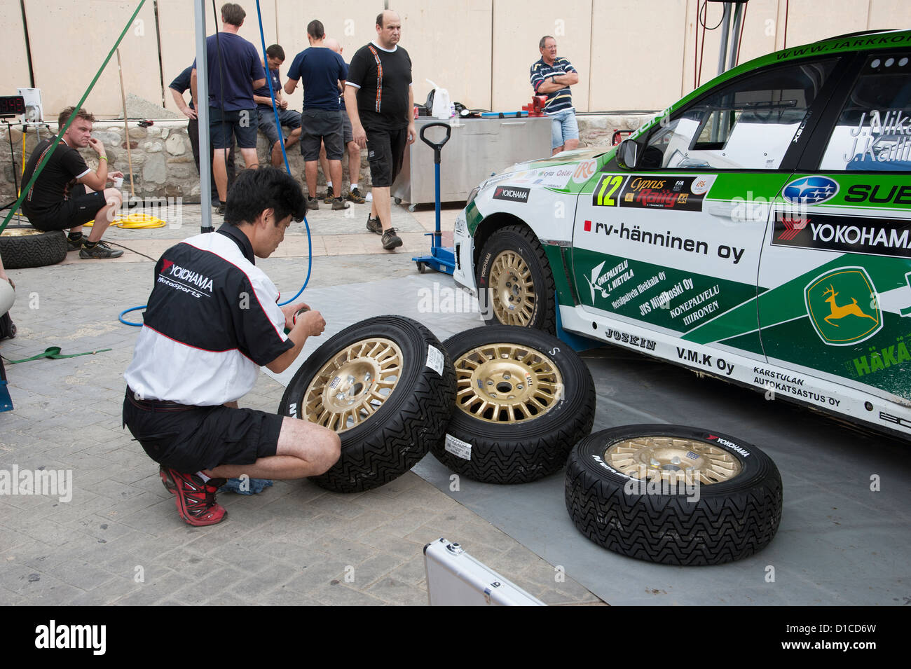 Zypern-Rallye 2012. Service-Techniker der Yokohama high-Performance-Reifen Tommi Makinen Straßenauto Stick auf Logos zuweisen Stockfoto