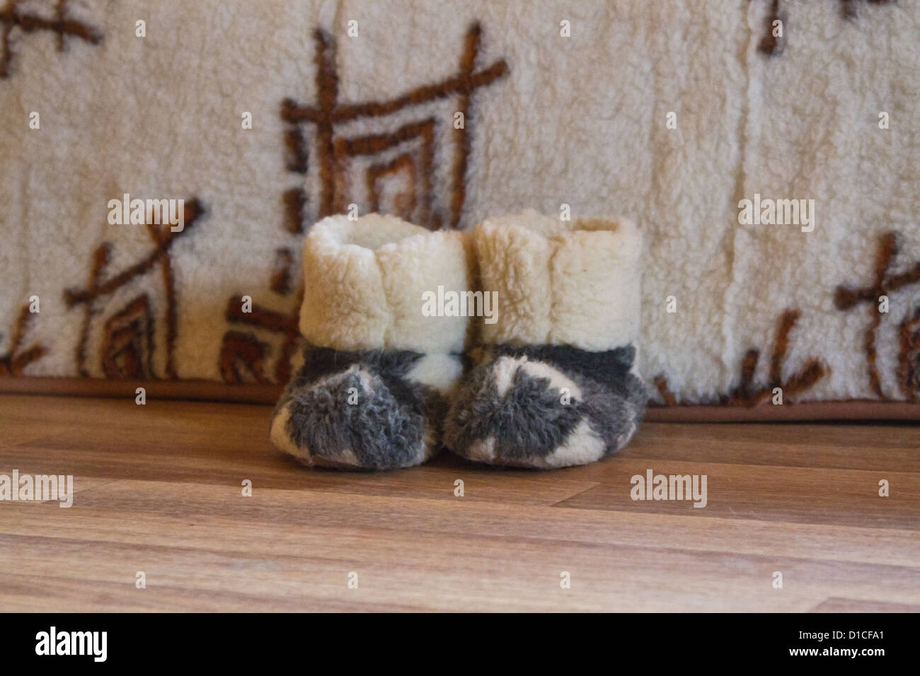 warme Hausschuhe auf dem Boden neben dem Bett Stockfoto