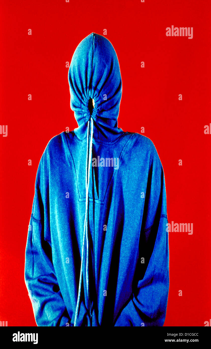 Heimliche Person in einem blauen Sweatshirt mit Kapuze, roter Hintergrund. Herr ©mak Stockfoto