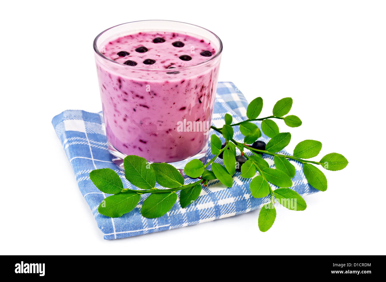 Das Glas Milch-Shake, grüner Zweig mit Heidelbeeren auf einer blau karierte Serviette isoliert auf weißem Hintergrund Stockfoto