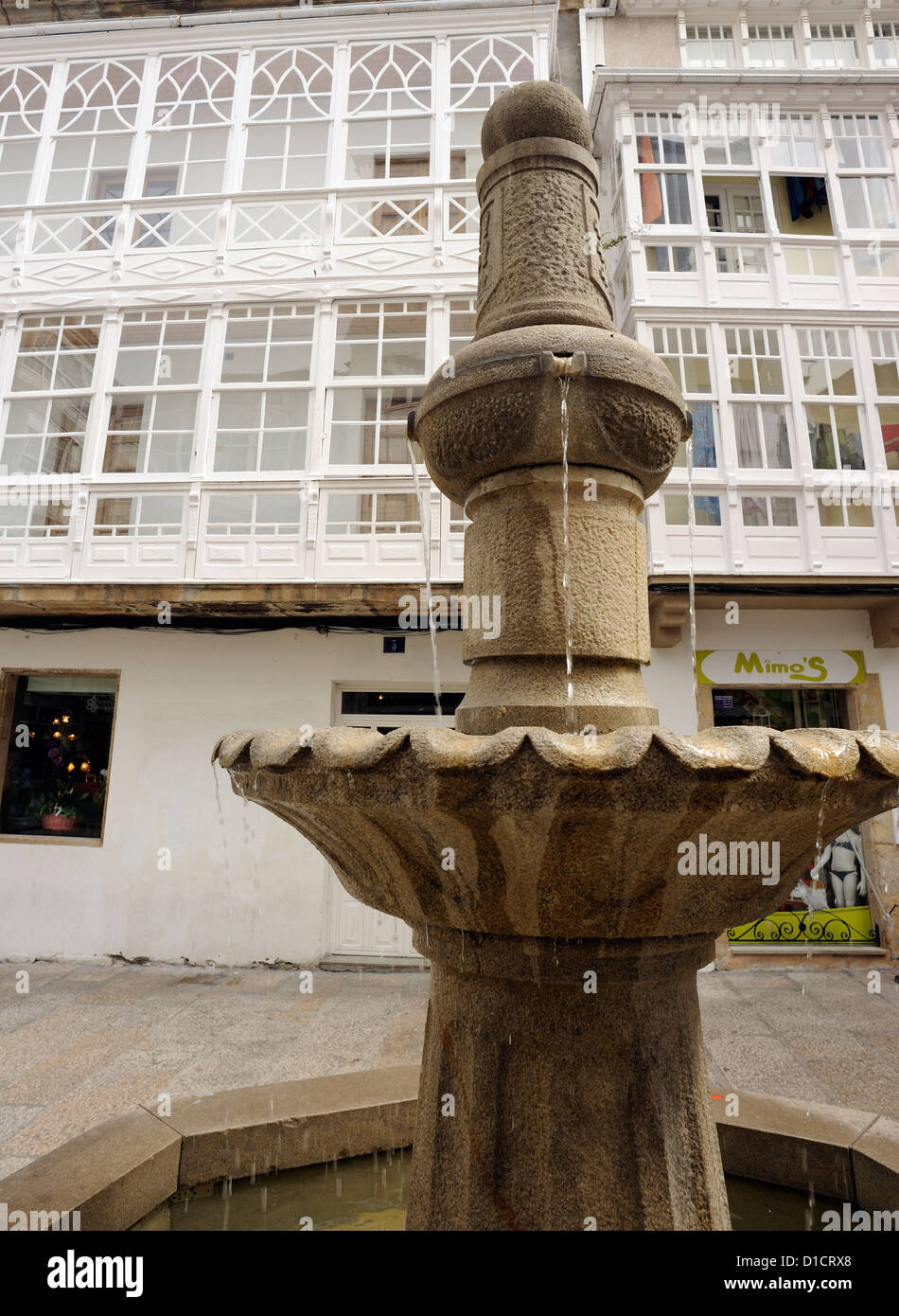 Brunnen in Viveiro Hauptplatz. Es ist ein Stadthaus mit traditionellen verglaste Fenster Balkon, Galerías. Viveiro, Galizien, Stockfoto