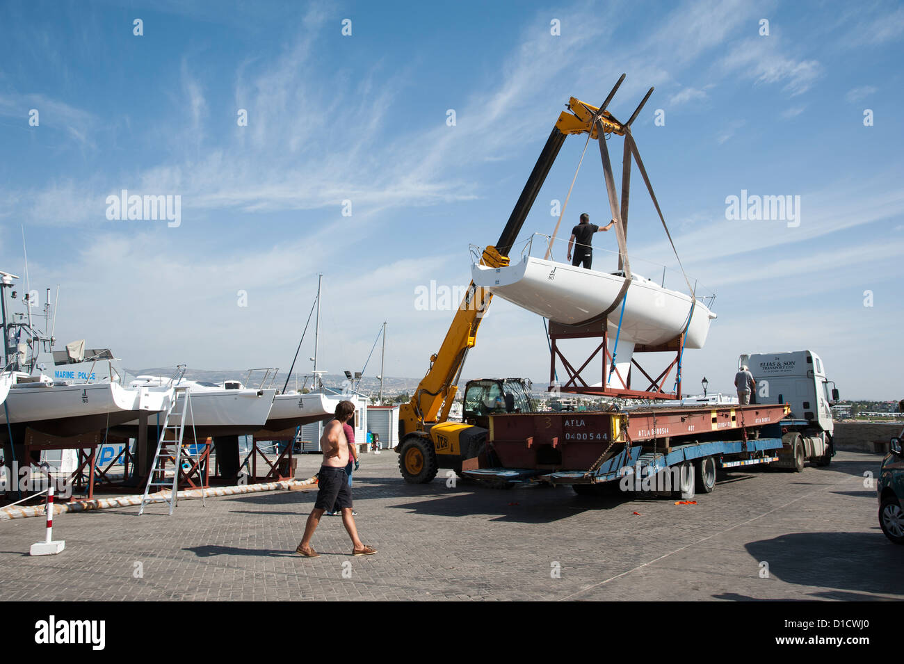 Kran, eine Monotypie J 80 Yacht von einem Tieflader LKW heben verwendet wird. Paphos Hafen Zypern Teil der Flotte Vermietung Yacht Stockfoto