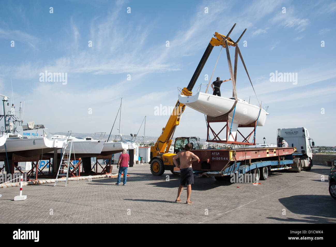 Kran, eine Monotypie J 80 Yacht von einem Tieflader LKW heben verwendet wird. Paphos Hafen Zypern Teil der Flotte Vermietung Yacht Stockfoto