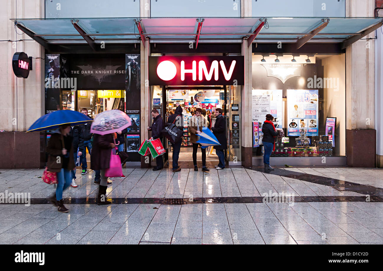 Shopper im Regen außerhalb der HMV speichern, Cardiff, Wales, UK Stockfoto