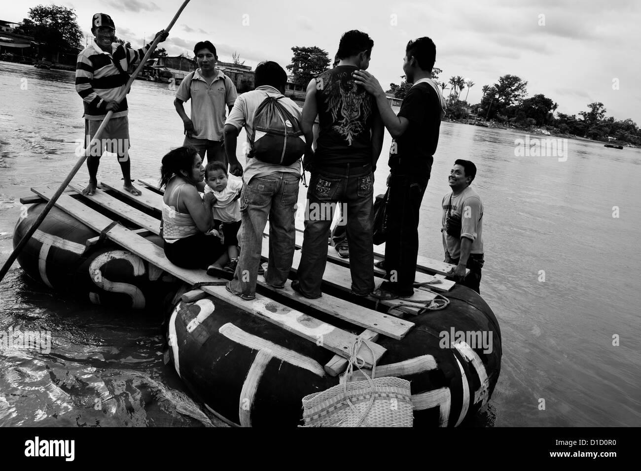 Eine behelfsmäßige Innenrohr Floß, mit Einwanderern aus Mittelamerika, verlässt die Ufer des Flusses in Tecún Umán, Guatemala. Stockfoto