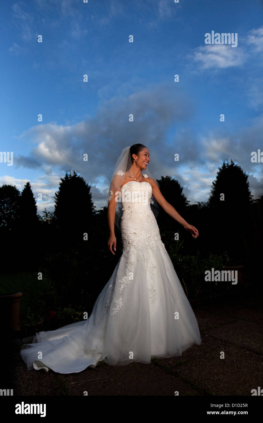 Braut im Hochzeitskleid unter dramatischen Abendlicht, England. UK Stockfoto