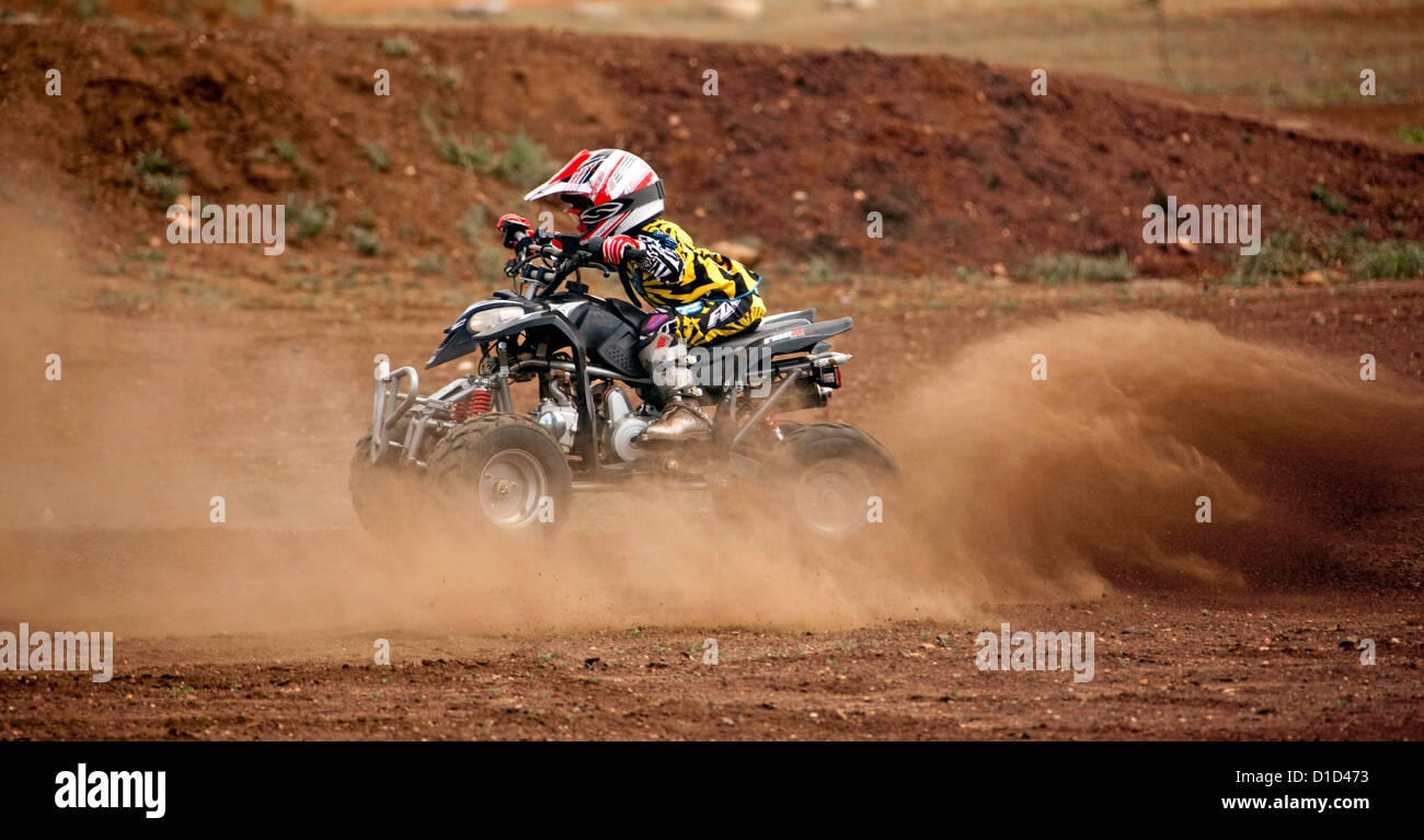 Kleines Kind - im Alter von vier - auf Quad-Bike tragen schützende Kleidung und Reiten auf Feldweg Stockfoto