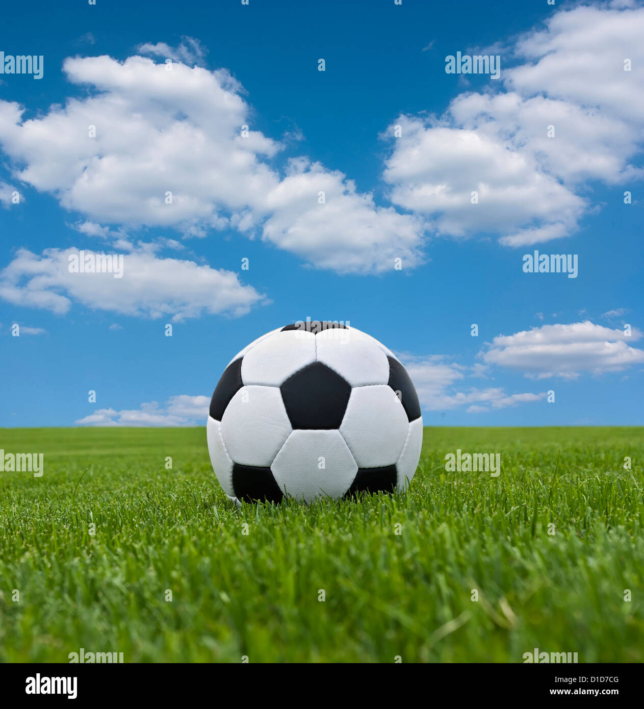 Fußball im grünen Rasen vor dem Hintergrund der Wolkengebilde Stockfoto