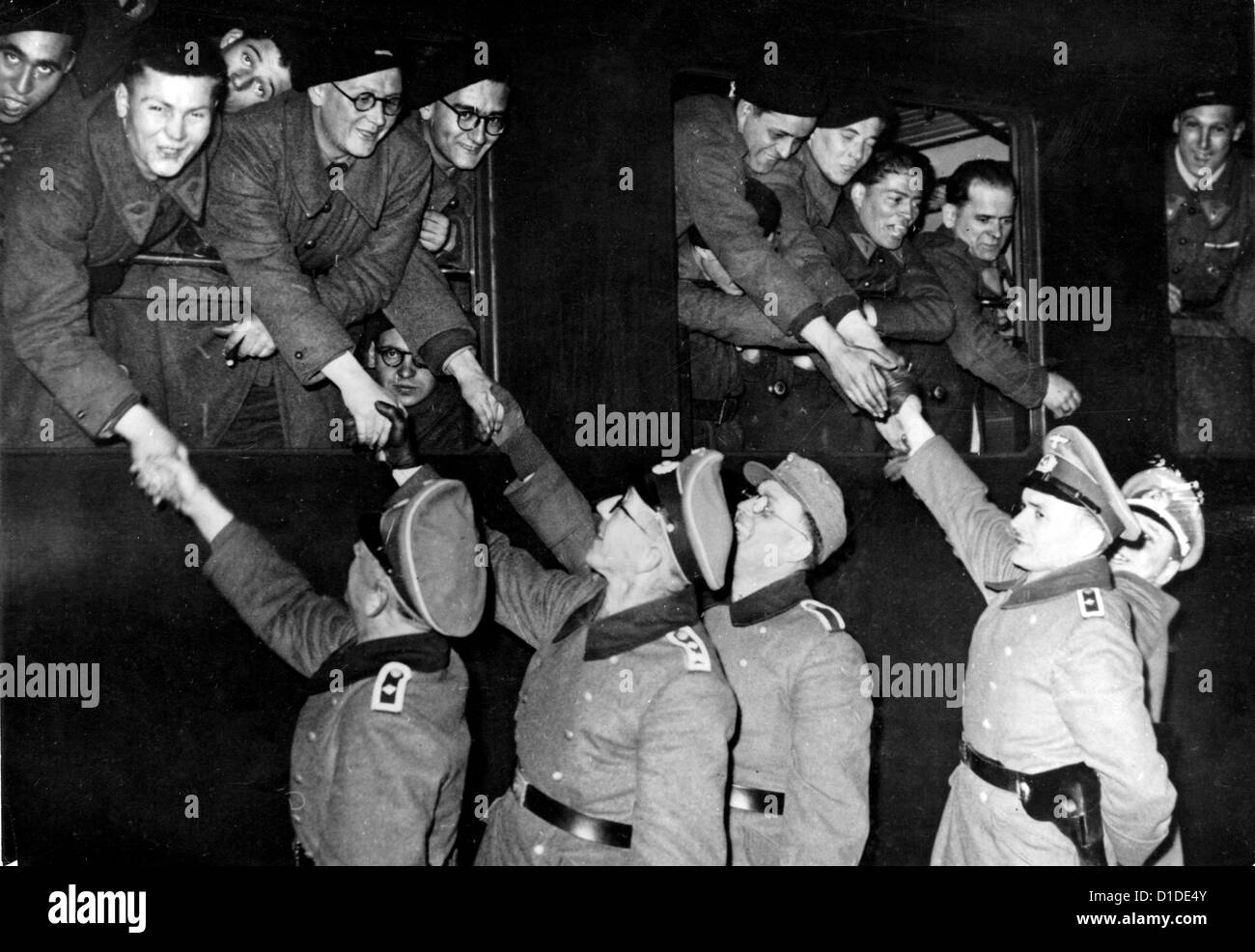 Soldaten der deutschen Wehrmacht schütteln den französischen Freiwilligen die Hand, die sich am 7. Juli 1944 auf dem Weg zur Front befinden. Ort unbekannt. Fotoarchiv für Zeitgeschichte Stockfoto