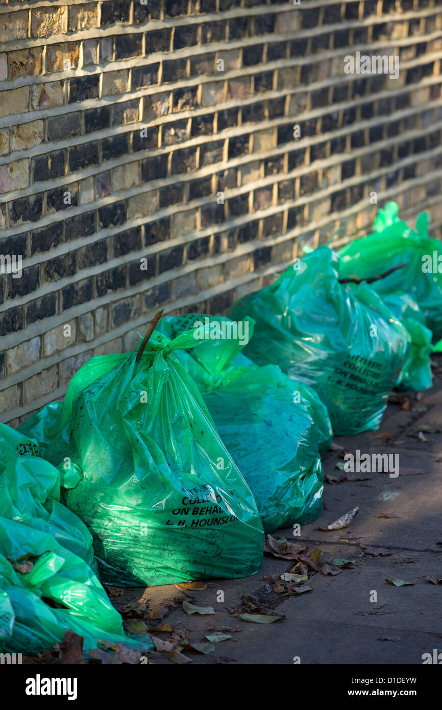 Grünen Müllsäcken von Hounslow Rat und gefüllt mit Herbstlaub aufgereiht bereit zur Abholung Stockfoto