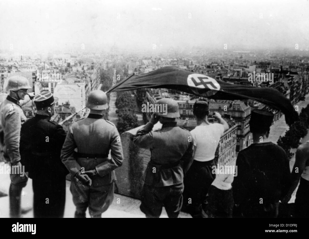 Soldaten der deutschen Wehrmacht und französische Kollaborateure hissen im Juni 1940 eine Hakenkreuz-Flagge auf dem Dach des Triumphbogens in Paris, Frankreich. Fotoarchiv für Zeitgeschichte Stockfoto