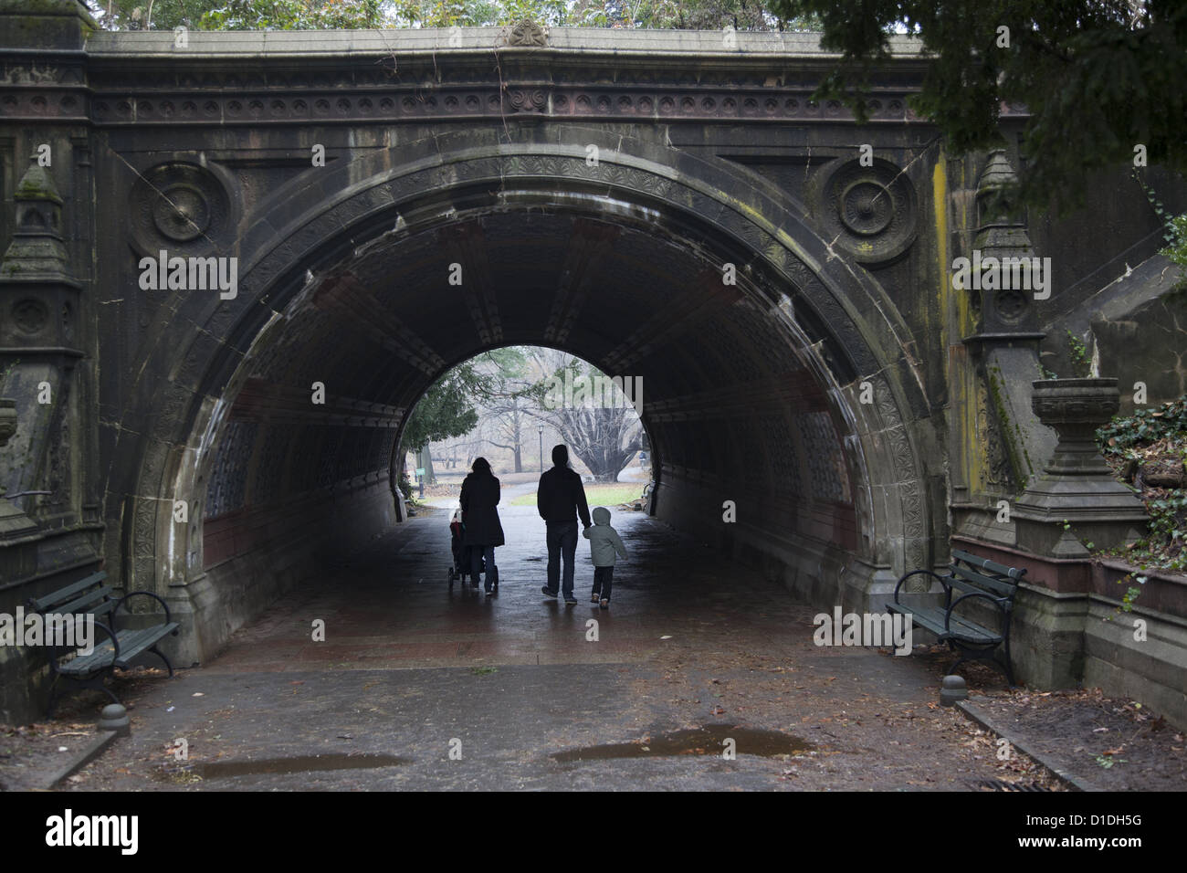 Junge Familie macht einen Spaziergang an einem regnerischen Novembermorgen in Prospect Park in Brooklyn, New York. Stockfoto