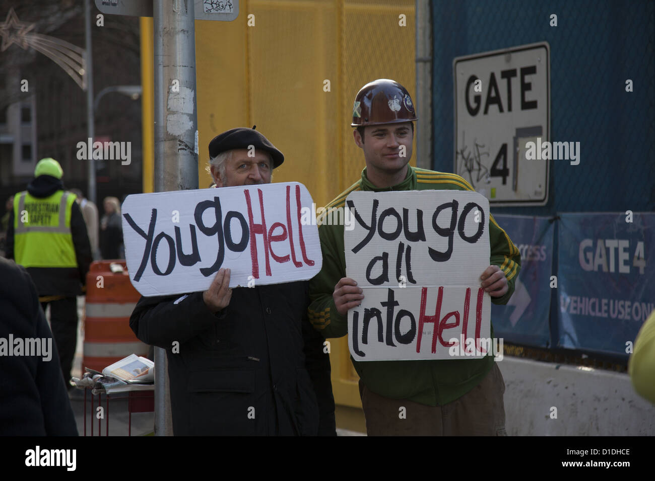Bauarbeiter posiert mit einem Mann ein Statement auf der anderen Straßenseite von der Baustelle des World Trade Center & 9/11 memorial Stockfoto