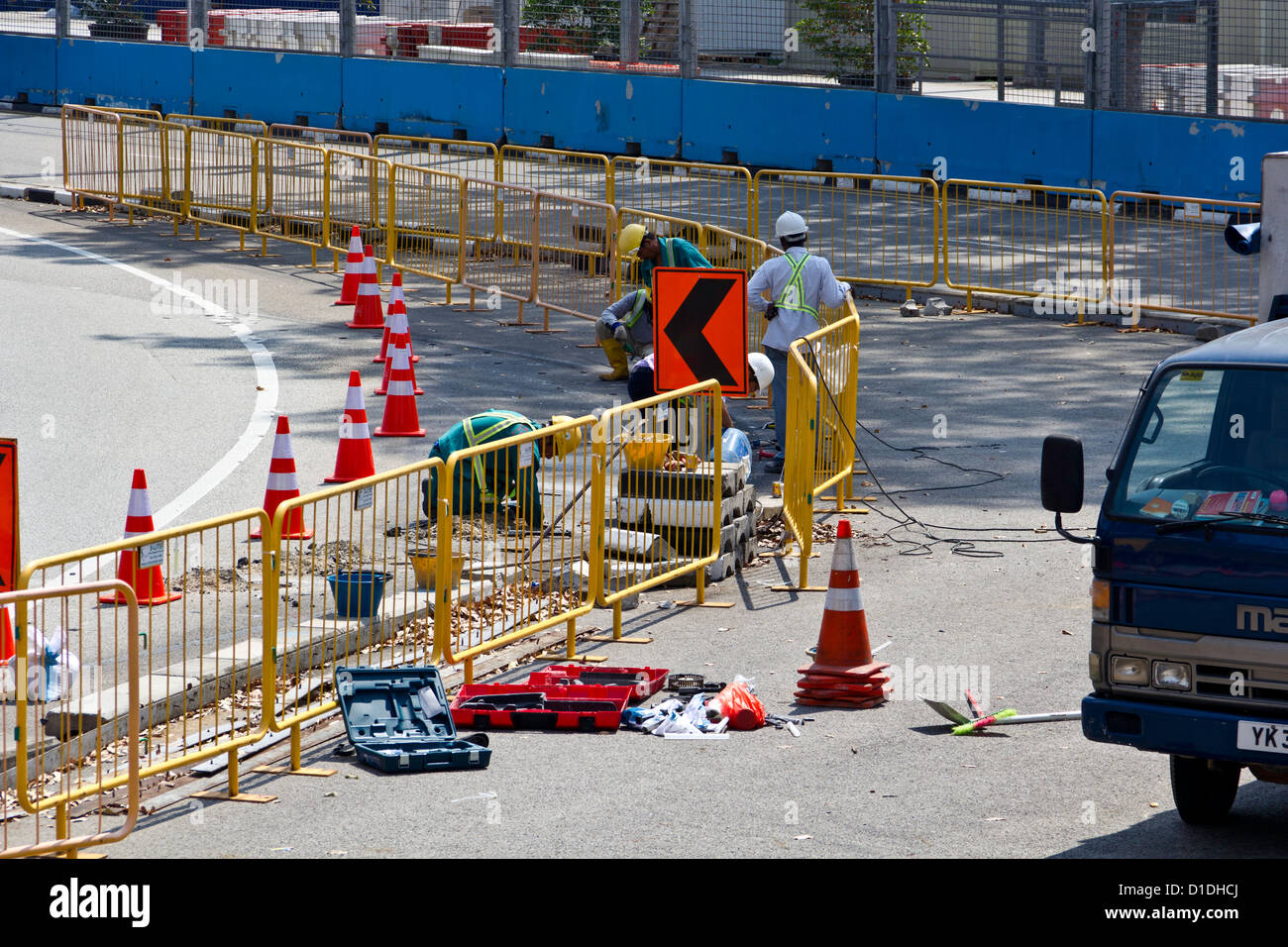 Arbeitnehmer, die auf der Fahrbahn, jährlich bereitet sie für das Formel1 Rennen auf den Straßen von Singapur Stockfoto