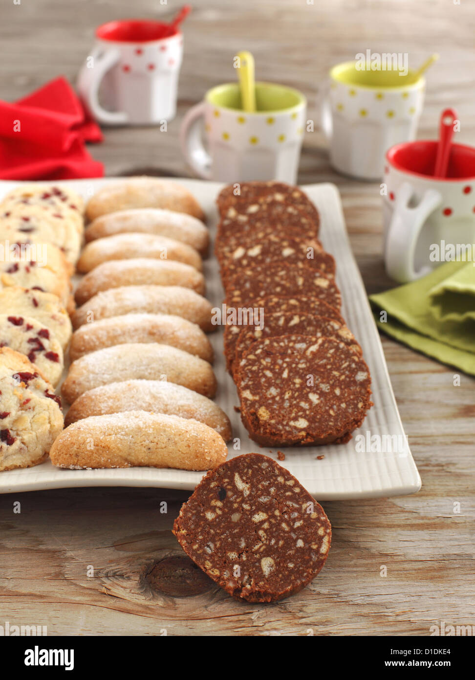 Halbmonde Vanille und Mandel Cookies, Schokolade Salami und Pecan Cookies mit Kirschen auf dem Teller Stockfoto