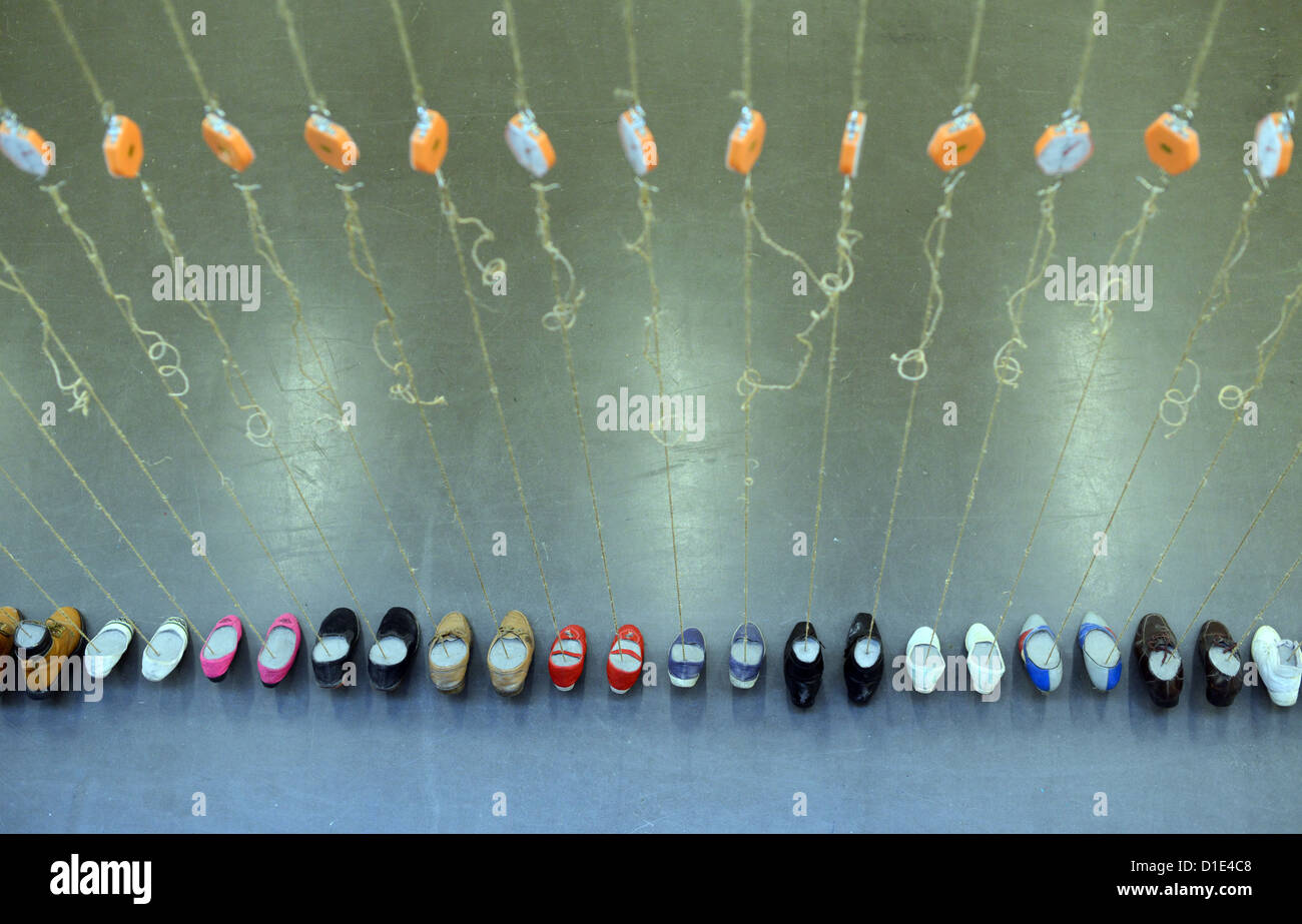 Schuhe hängen am Objekt "Zement Schuhe" des chinesischen Künstlers Yin Xiuzhen in der Kunsthalle Düsseldorf, 14. Dezember 2012. Die Ausstellung ist geöffnet vom 15. Dezember 2012 bis 10. März 2013. Foto: Caroline Seidel Stockfoto