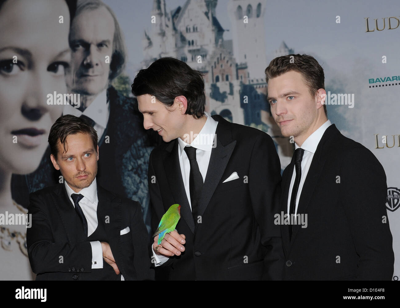 Deutsch-rumänischen Schauspieler Sabin Tambrea Posen mit dem Vogel aus dem Film, Pygmy Papagei "Edith" und Kollegen Tom Schilling (L) und Friedrich Muecke (R) bei der Weltpremiere des historischen Films "Ludwig II" im HVB Forum in München, 13. Dezember 2012. Der Film wird am 26. Dezember 2012 in die deutschen Kinos kommen. Foto: Ursula Düren Stockfoto