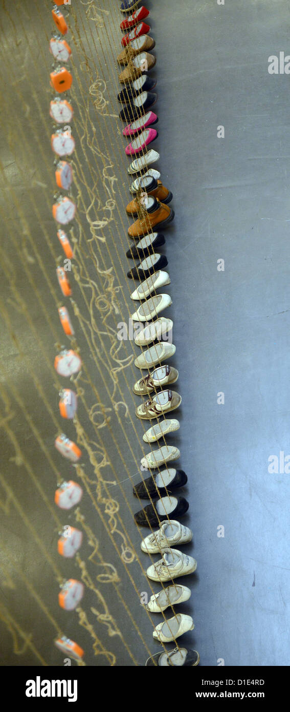 Schuhe hängen am Objekt "Zement Schuhe" des chinesischen Künstlers Yin Xiuzhen in der Kunsthalle Düsseldorf, 14. Dezember 2012. Die Ausstellung ist geöffnet vom 15. Dezember 2012 bis 10. März 2013. Foto: Caroline Seidel Stockfoto