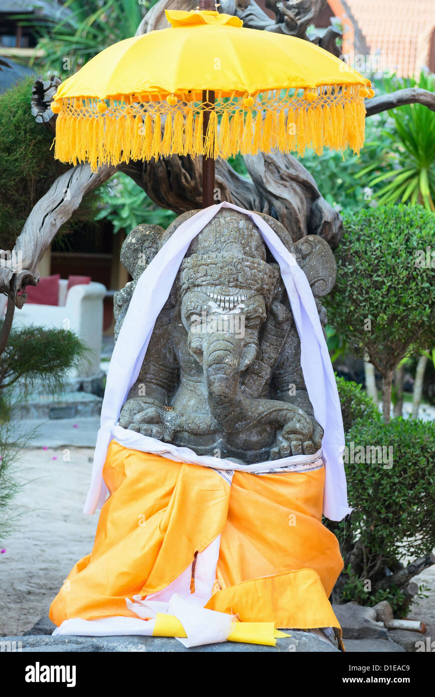 Ganesha-Skulptur mit gelben Stoff und Regenschirm im Bali Stil dekoriert Stockfoto