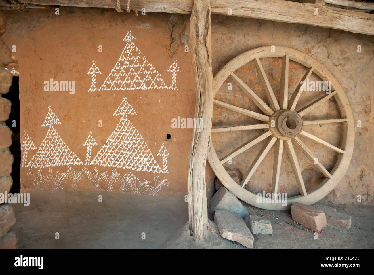 Dorf Hauswand mit typischen Orissa Reis Mehl Malerei und hölzerne Wagenrad Naupatana Weberei Dorf, ländlichen Orissa, Indien Stockfoto