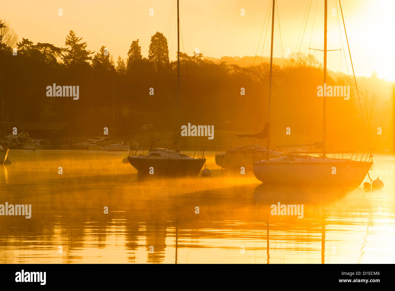 Segelboote am Lake Windermere am Waterhead, Ambleside, Seenplatte, bei Sonnenaufgang, UK, mit Willen o wisp Nebel. Stockfoto