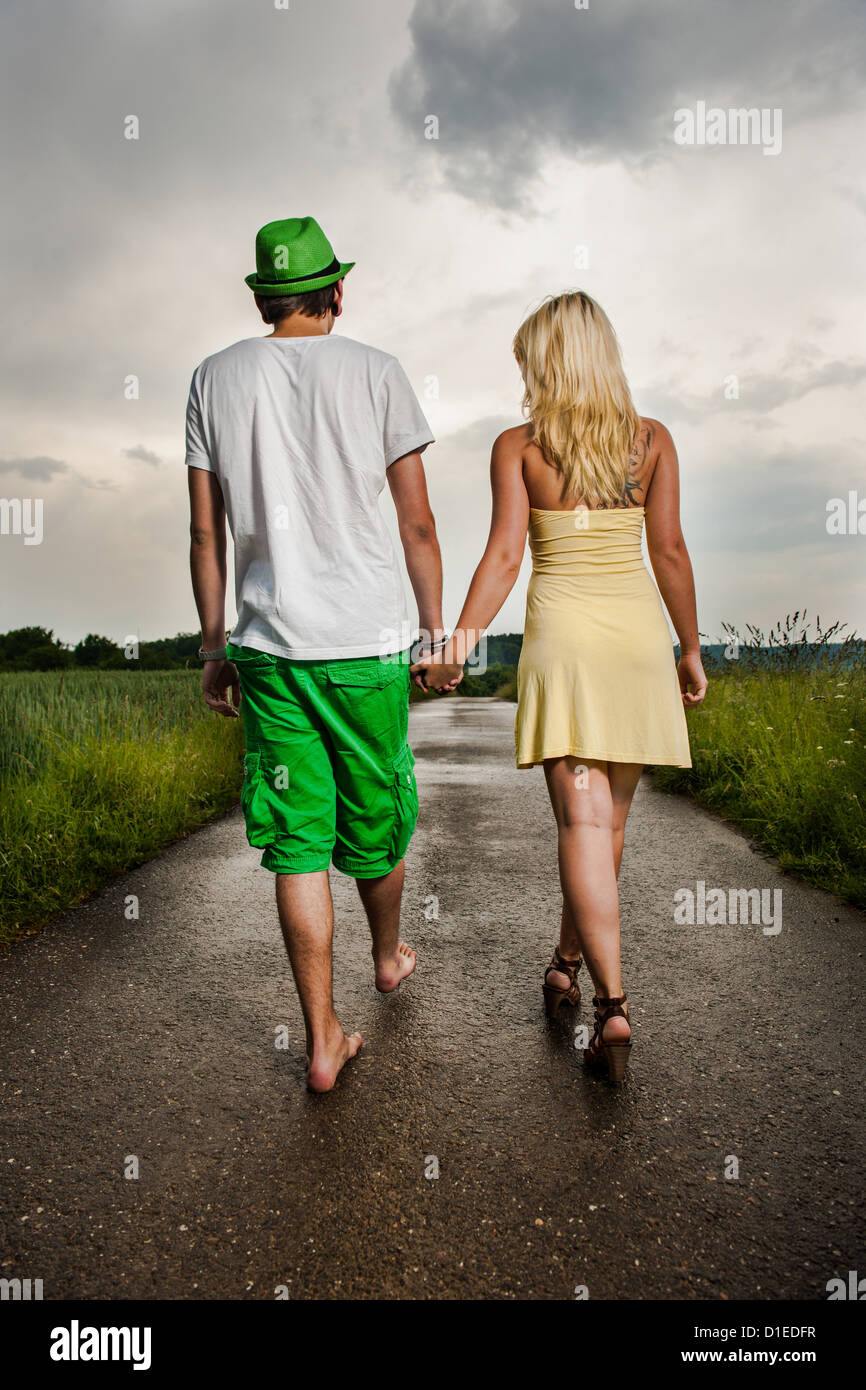 Junges Paar gehen Hand in Hand in ländlichen Landschaft Stockfoto