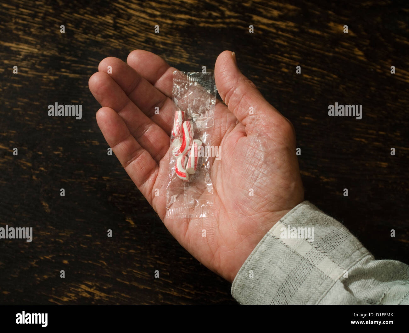 Hand mit gebrochenen Zuckerstange Stockfoto