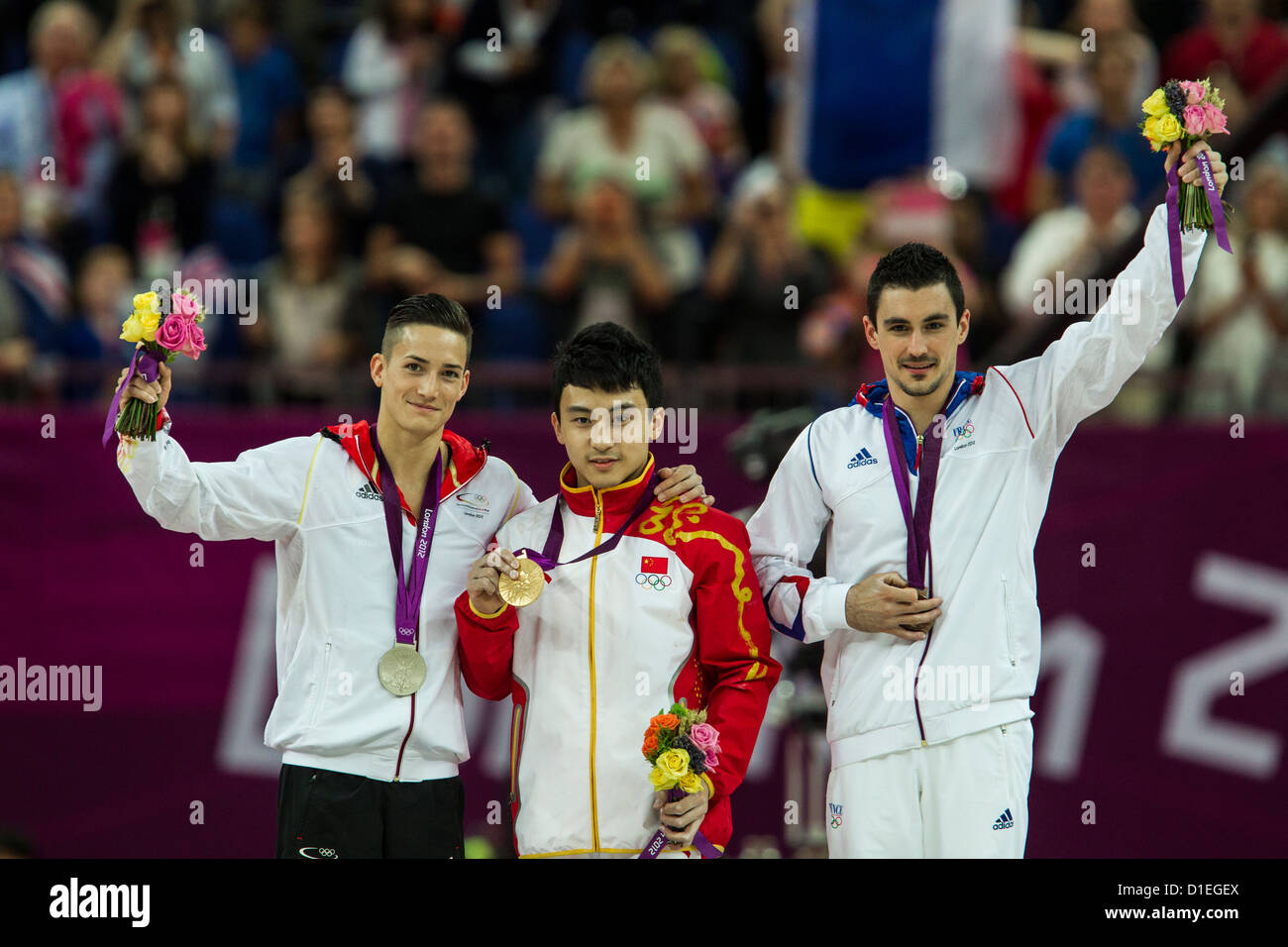 Feng Zhe (CHN) - C - Gewinner der Goldmedaille im Herren Finale Barren mit Marcel Nguyen (GER) - L-Silber Stockfoto
