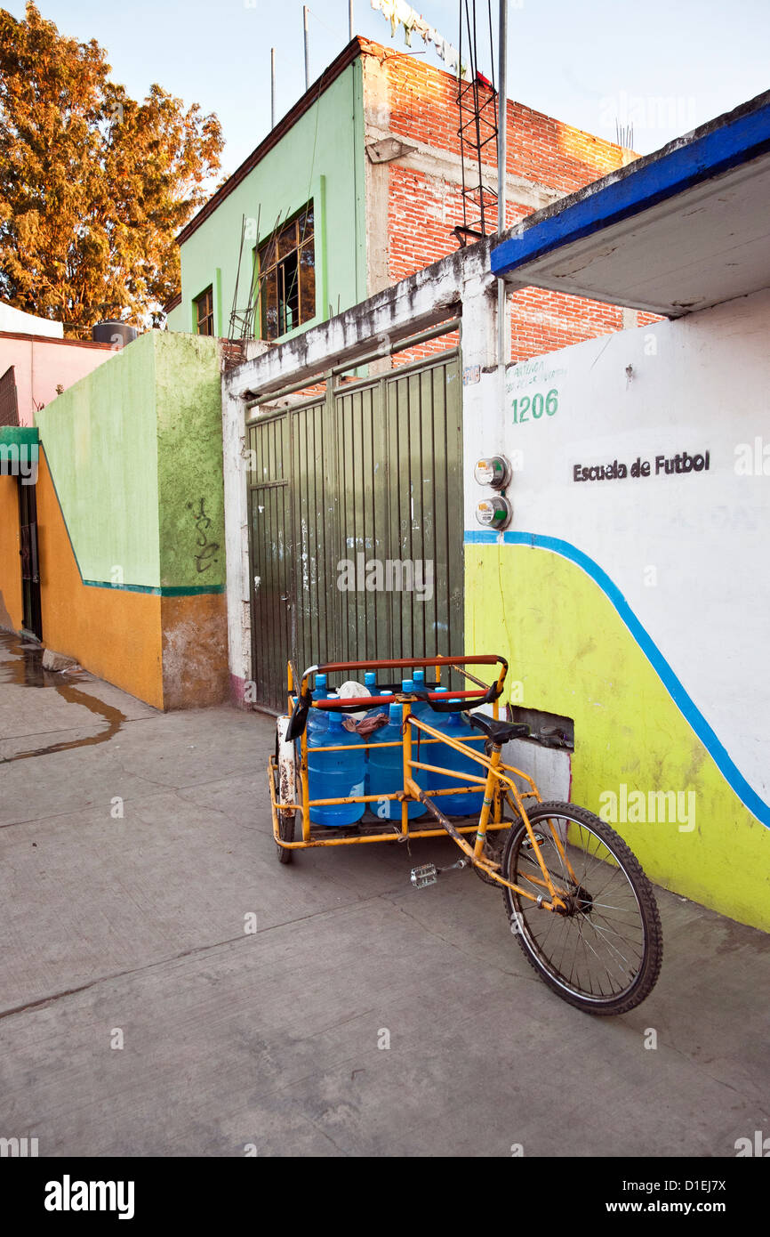 gereinigtes Wasser Anbieter Frontlader Dreirad Wagen geparkt neben Häuserreihe bunt bemalten Oaxaca de Juárez, Mexiko Stockfoto