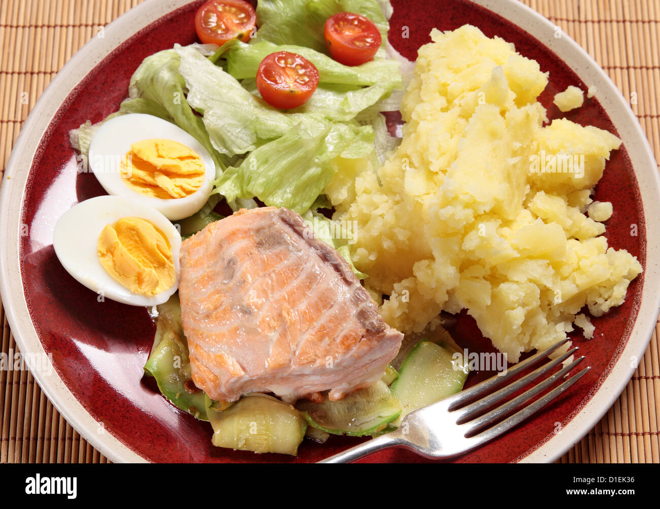 Gegrillter Lachs auf Splitter aus gebratenen Cougette mit einem gekochten Ei, Salat und Kartoffelpüree serviert Stockfoto