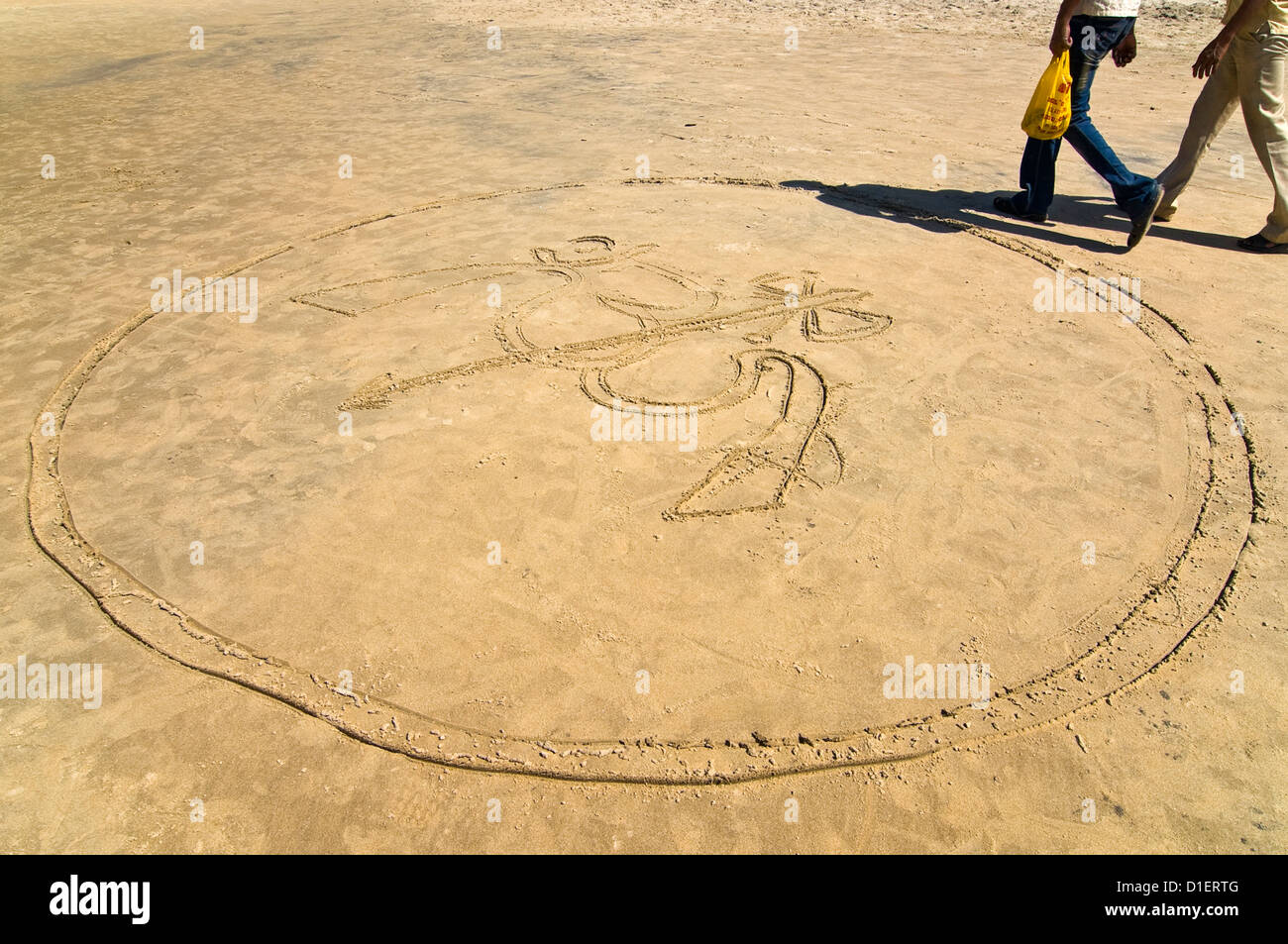 Horizontale Ansicht von 'Om' geschrieben in den Sand am Strand von Varkala, Kerala reinwaschen. Stockfoto