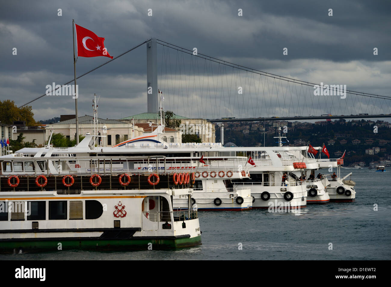 Fähre und Tour Boote bei Besiktas Pier mit den ersten Bosporus-Brücke und die türkische Fahne Istanbul Türkei Stockfoto