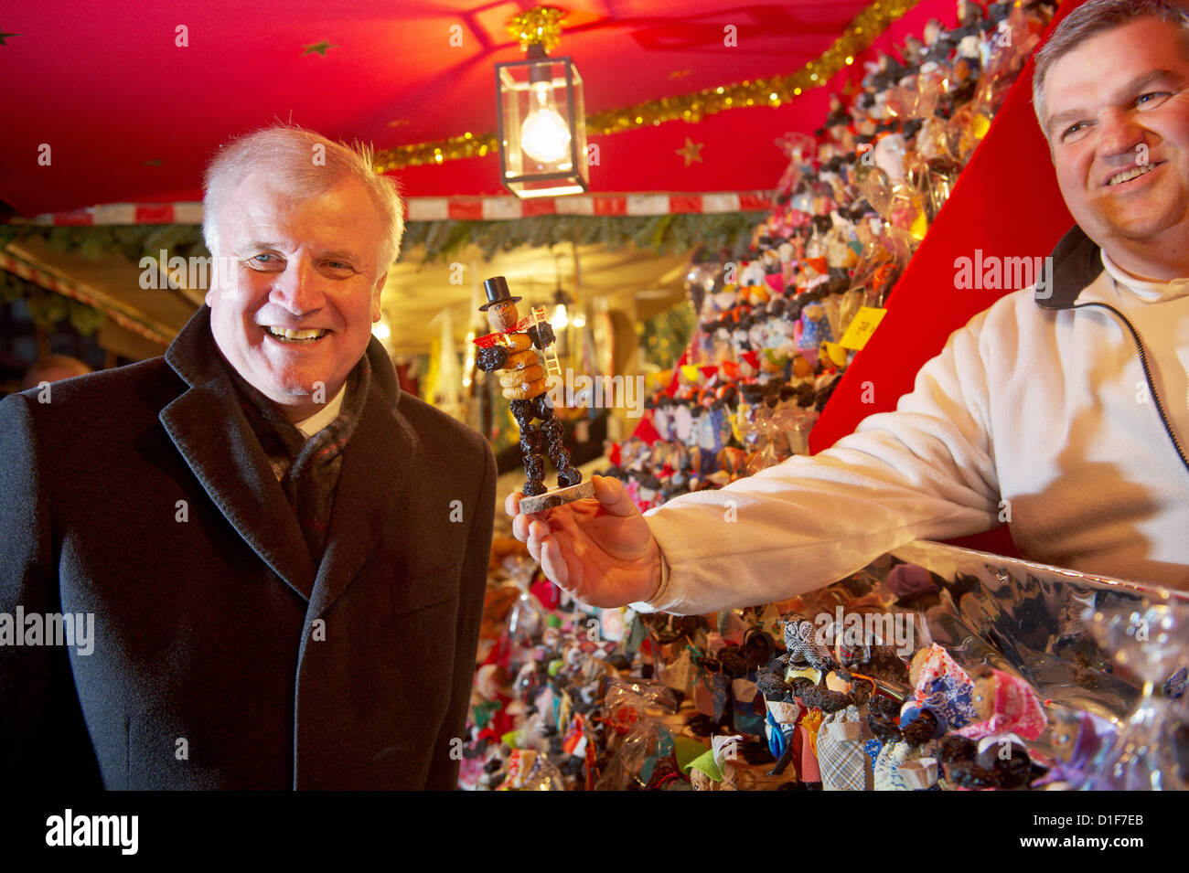 Premier von Bayern Horst Seehofer (L) erhält einen Pflaume Mann als Geschenk an den Christkindlemarkt nach der Kabinettssitzung in Nürnberg, 18. Dezember 2012. Foto: DAVID EBENER Stockfoto