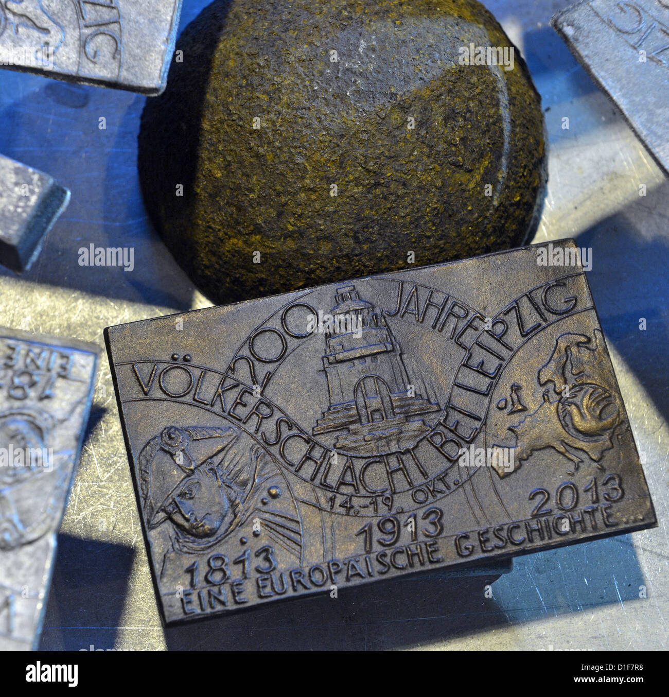 Die Besetzung Medaille zum Jubiläum der Völkerschlacht sitzt neben einer Kanonenkugel in der Gießerei der Freiberger Universität für Bergbau und Technologie in Freiberg (Sachsen), Deutschland, 18. Dezember 2012. Die Medaillen für den 200. Jahrestag der Schlacht bestehen aus Kanonenkugeln von 1813 fanden auf den Schlachtfeldern um Leipzig. Zunächst ist es eine limitierte Auflage von 600 Medaillen. Foto: Hendrik Schmidt Stockfoto
