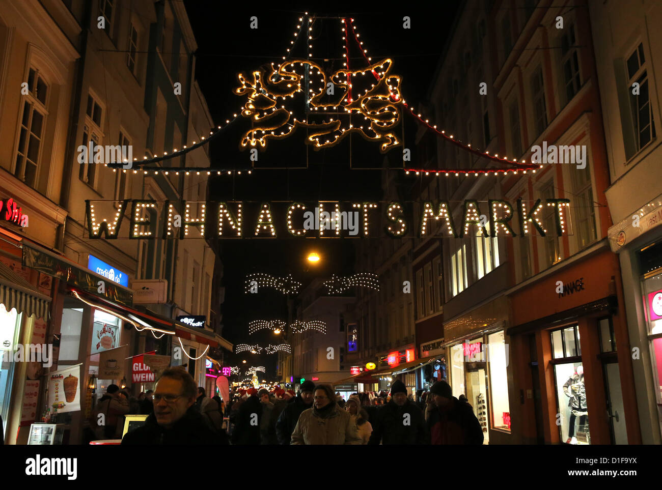 Besucher schlendern entlang der beleuchteten Weihnachtsmarkt in Rostock, Deutschland, 14. Dezember 2012. Der größte Weihnachtsmarkt im Norden Deutschlands erstreckt sich eine Veneris von 3,2 Kilometern und bis 22. Dezember 2012 öffnet. Foto: Bernd Wuestneck Stockfoto