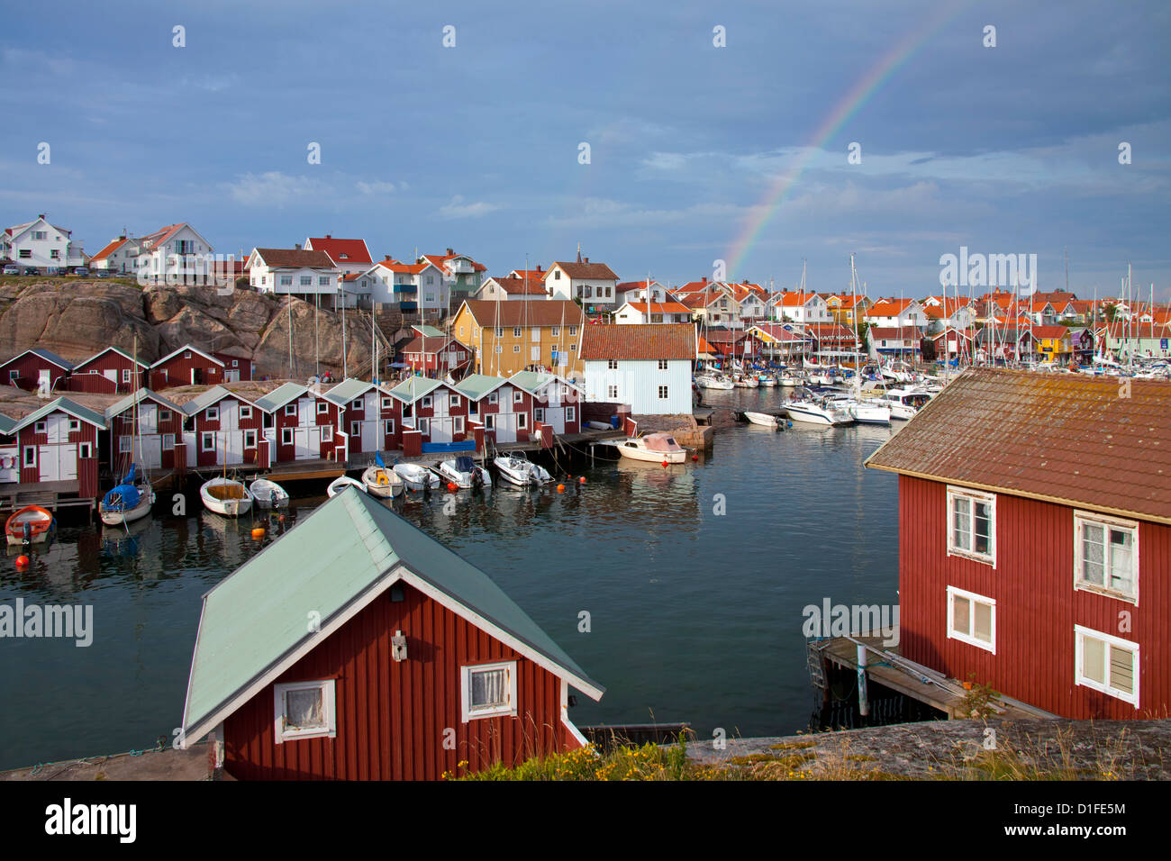 Bunten traditionellen Fischerhütten und Bootshäuser mit Booten entlang Holzmole im Smögen, Bohuslän, Schweden, Scandinavia Stockfoto