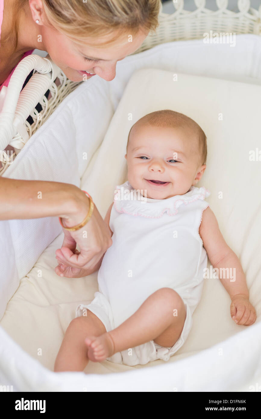 Kaukasische Mutter betrachten Baby in Wiege Stockfoto