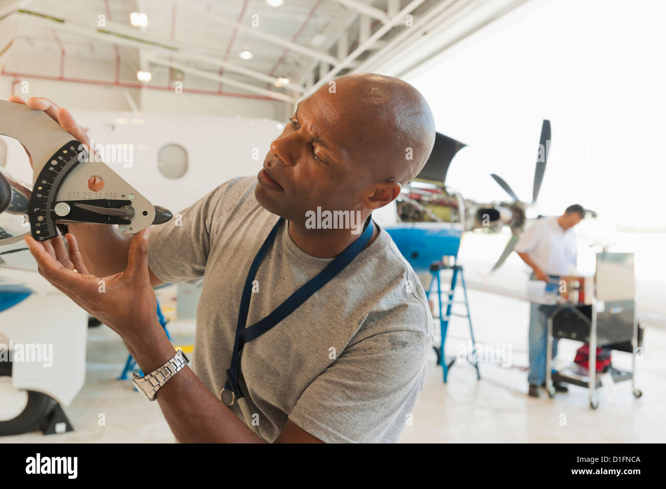 Afrikanische amerikanische Mann arbeitet im Flugzeughangar Stockfoto