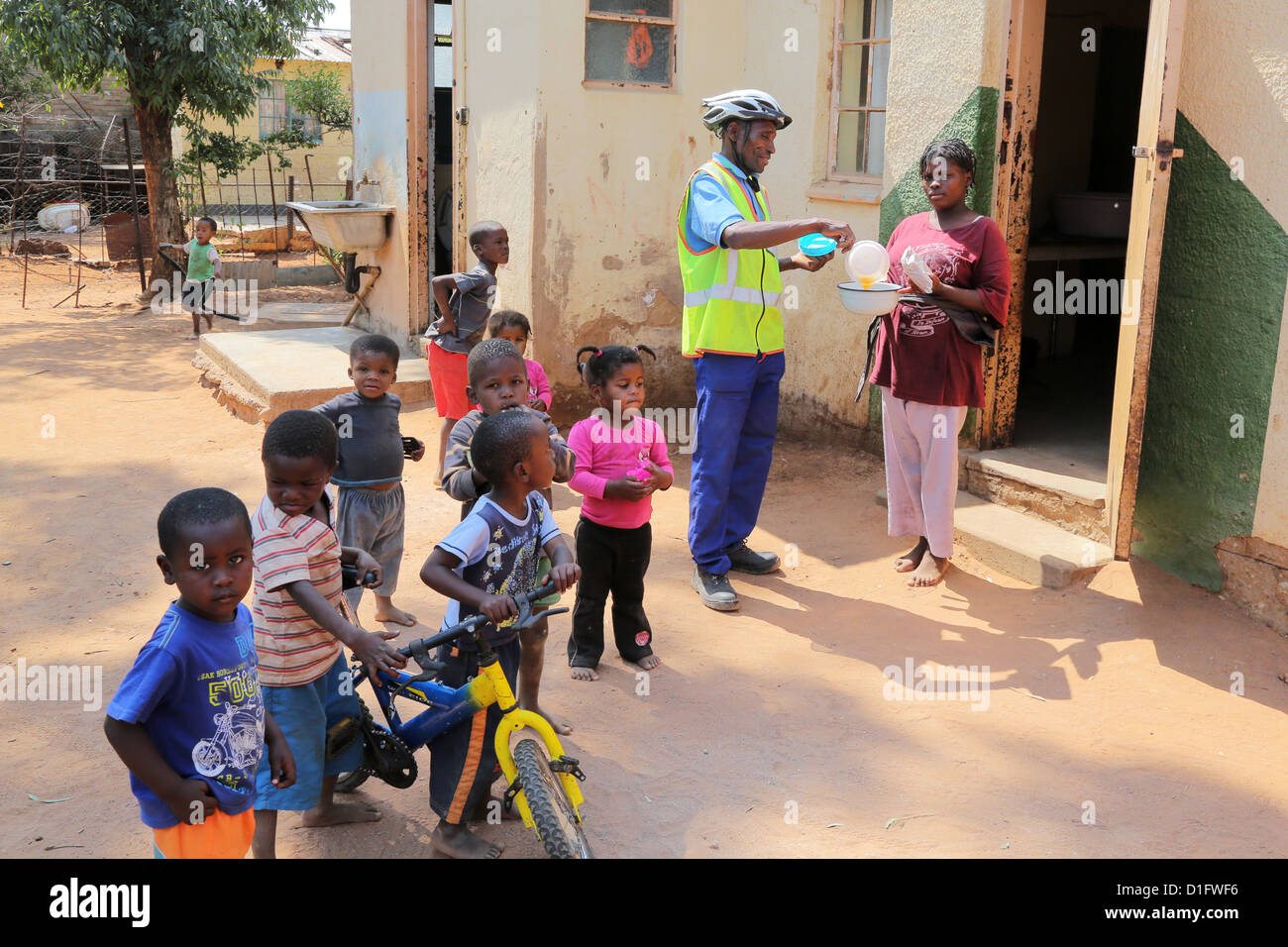 Freiwilliger Leoni´s Care Center NGO in Tsumeb/Namibia bringt Suppe in den Armen einer Gemeinde Stockfoto