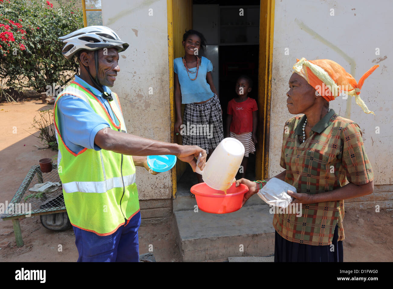 Freiwilliger Leoni´s Care Center NGO in Tsumeb/Namibia bringt Suppe in den Armen einer Gemeinde Stockfoto