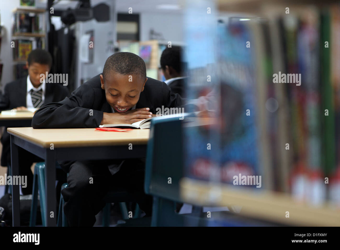 Afro-karibischen jungen studieren Lesung in der Bibliothek Stockfoto
