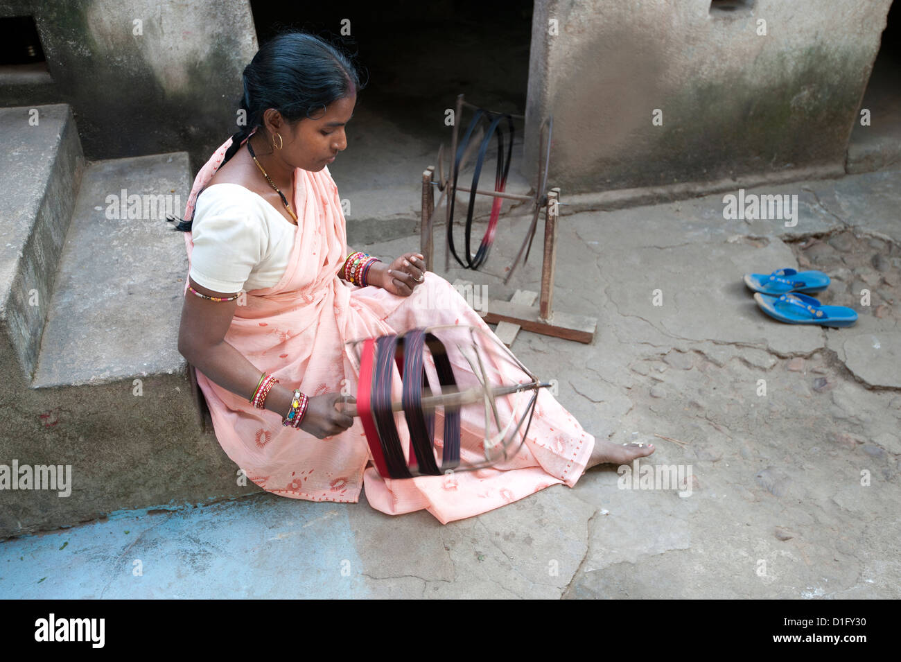 Frau dreht Seidenfaden von hand außerhalb ihres Hauses, Vaidyanathpur, Orissa, Indien, Asien Stockfoto
