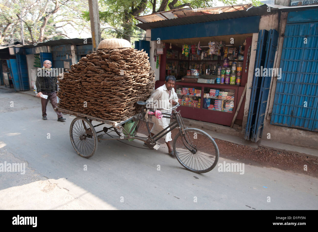 Machenschaften Fahrradrikscha beladen mit Kot Mann klopft für den Einsatz als Hausbrand, Hugli Village, West Bengalen, Indien, Asien Stockfoto