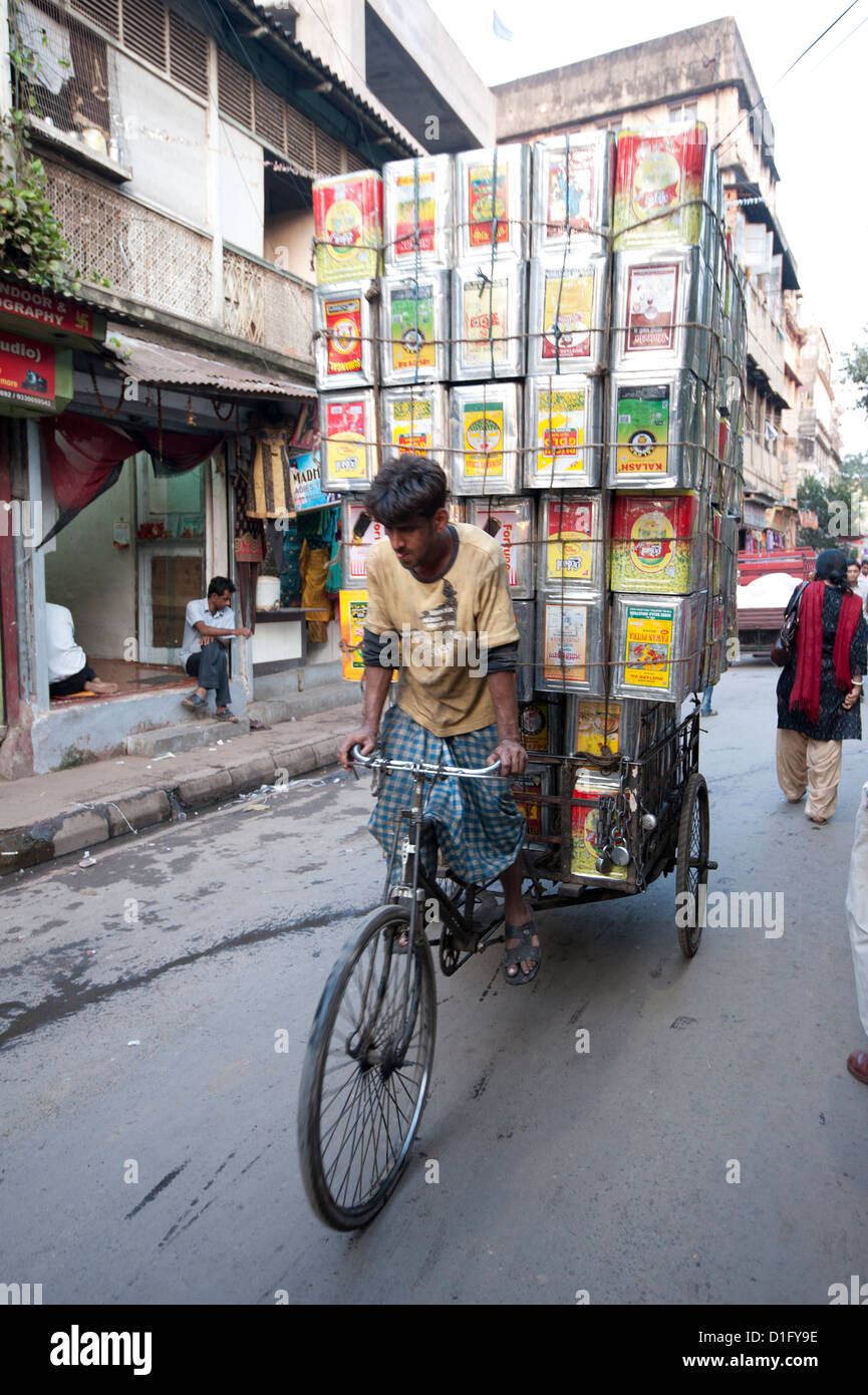 Fahrradrikscha tragen riesige Ladung Öl Dosen durch Markt, Kolkata (Kalkutta), West Bengalen, Indien, Asien Stockfoto