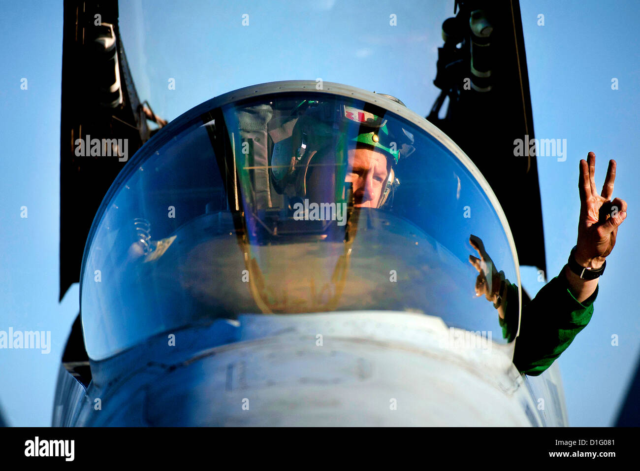 US Navy Mechaniker signalisiert ein Flugzeug-Kapitän bei der Problembehandlung Systeme auf einer F/A - 18C Hornet auf dem Flugdeck an Bord der Flugzeugträger der Nimitz-Klasse USS Carl Vinson Februar 2012 im arabischen Meer. Stockfoto